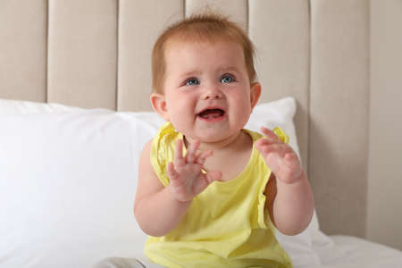 Cute little redhead baby on bed at home