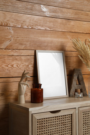 Empty frame with other decor on table near wooden wall. Mockup for designの写真素材