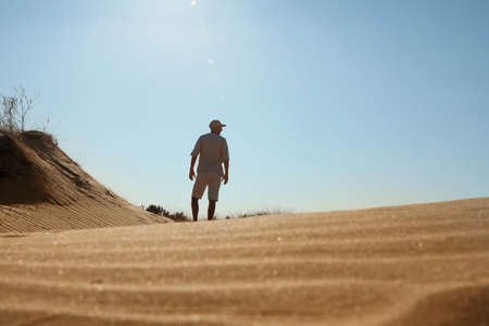 Man in desert on sunny day, back viewの写真素材