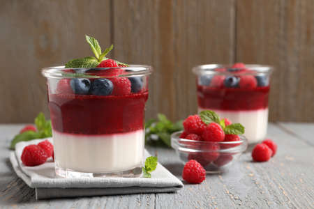 Delicious panna cotta with berries on gray wooden tableの写真素材