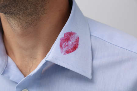 Man in shirt with lipstick kiss mark on white background, closeupの写真素材