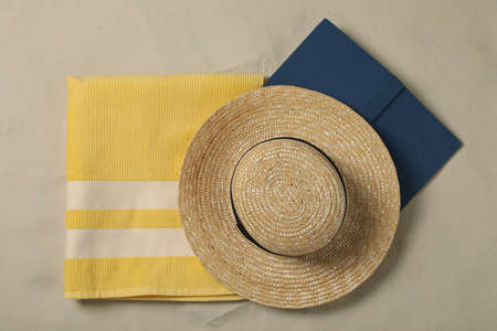 Beach towel, hat and book on sand, top viewの写真素材