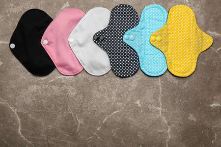 Many reusable cloth menstrual pads on brown table, flat lay. Space for textの写真素材