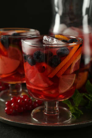 Glass of Red Sangria with fruits on black table
