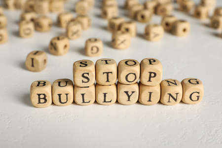 Phrase Stop Bullying made of wooden cubes with letters on stone surface, closeupの写真素材