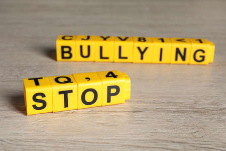 Phrase Stop Bullying made of yellow cubes with letters on wooden table, closeupの写真素材