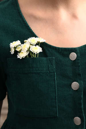 Woman wearing shirt with flowers in pocket, closeup