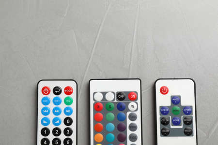 Remote controls on gray table, flat lay. Space for textの写真素材