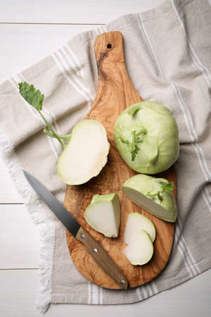 Whole and cut kohlrabi plants on white wooden table, flat layの写真素材