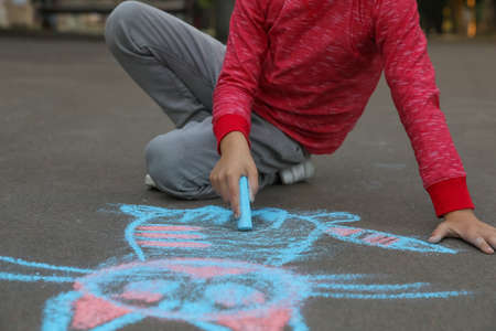 Child drawing cat with chalk on asphalt, closeupの写真素材