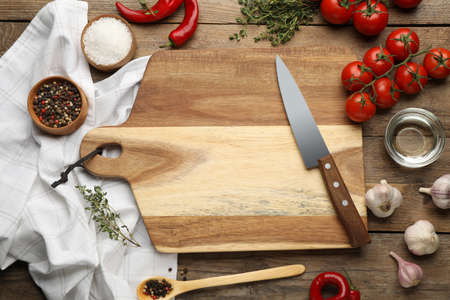 Flat lay composition with cutting board and ingredients on wooden table. Cooking utensilsの写真素材