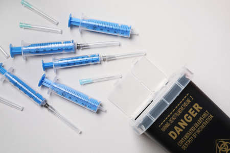 Disposable syringes, needles and sharps container on light background, flat layの写真素材