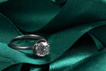 Beautiful luxury engagement ring with gemstone on green ribbon, closeupの写真素材