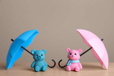 Small umbrellas and toy bears on wooden tableの写真素材