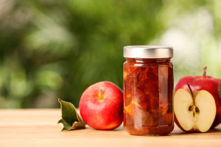 Delicious apple jam and fresh fruits on wooden table. Space for textの写真素材