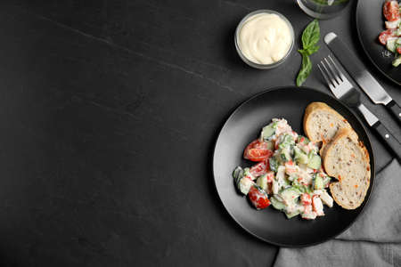Delicious salad with mayonnaise served on black table, flat lay. Space for text