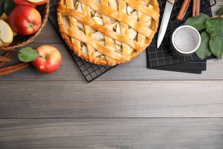 Delicious traditional apple pie on wooden table, flat lay. Space for textの写真素材