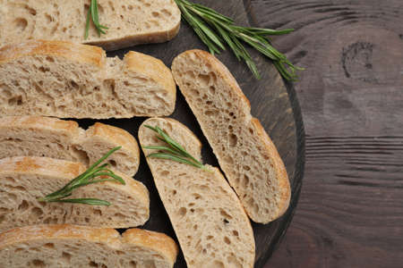 Delicious ciabatta with rosemary on wooden table, top viewの写真素材