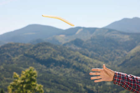 Man throwing boomerang in mountains, closeup viewの写真素材