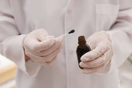 Doctor holding bottle of brilliant green and cotton bud, closeupの写真素材