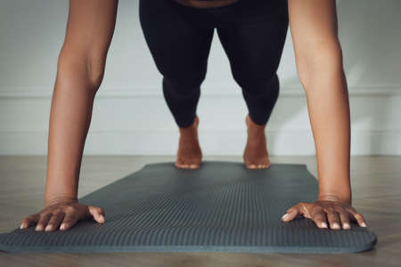Young woman doing plank exercise indoors, closeup