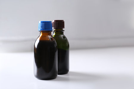 Bottles of brilliant green on white table. Space for textの写真素材