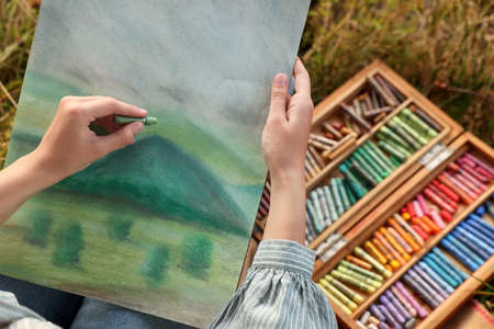 Woman drawing landscape with soft pastels outdoors, closeupの写真素材