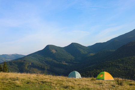 Picturesque mountain landscape with camping tents in morningの写真素材