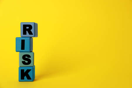 Word Risk made of colorful cubes on yellow background, space for textの写真素材