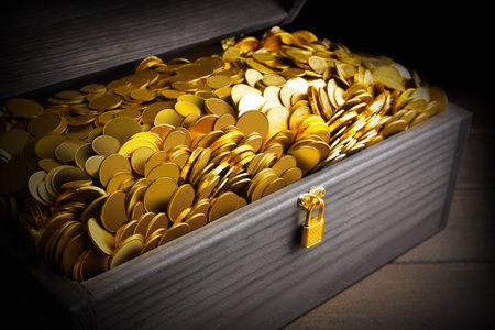 Open treasure chest with gold coins on wooden table, closeupの写真素材