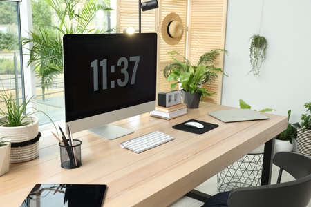Comfortable workplace with computer in light room. Interior design