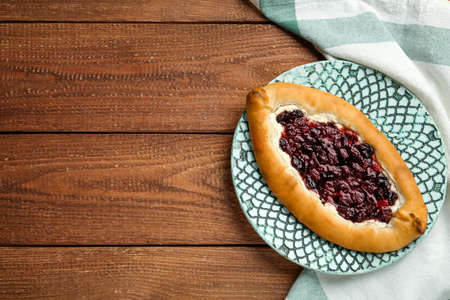 Delicious sweet cottage cheese pastry with cherry jam on wooden table, top view. Space for textの写真素材