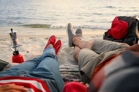 Couple resting near sea, closeup. Beach camping