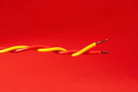 Two different electrical wires on red backgroundの写真素材