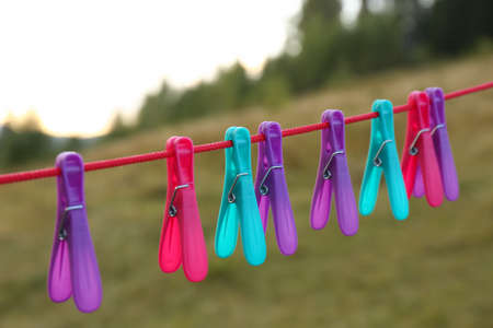 Colorful clothespins hanging on washing line outdoors