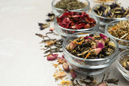 Different dry aromatic teas on light table, space for textの写真素材