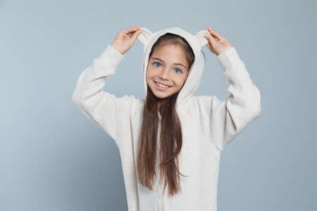 Cute girl in adorable white pajamas on light gray backgroundの写真素材