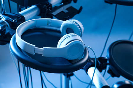 Modern electronic drum kit with headphones on light background, toned in blue. Musical instrumentの写真素材