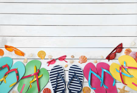Many different stylish flip flops and sunglasses on white wooden background, flat lay. Space for textの写真素材