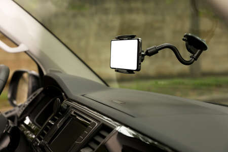 Car holder with modern mobile phone on windshield of automobile. Mockup for designの写真素材