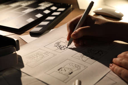 Woman drawing cartoon sketches at workplace, closeup. Pre-production processの写真素材