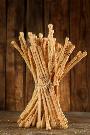 Bunch of delicious grissini sticks on wooden table
