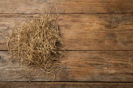 Dried hay on wooden background, top view. Space for textの写真素材