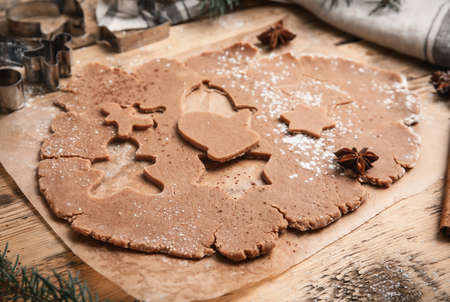 Making Christmas cookies. Raw dough and cutters on wooden tableの写真素材