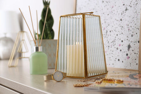 Beautiful holder with burning candle and stylish accessories on table indoorsの写真素材