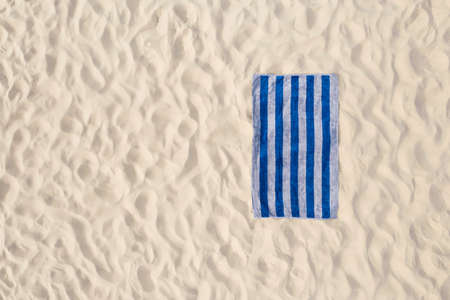 Striped beach towel on sand, aerial view. Space for textの写真素材