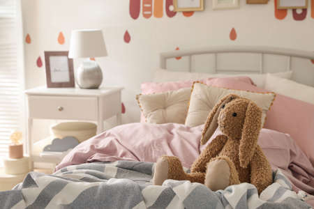 Toy bunny on bed in child's room. Interior designの写真素材