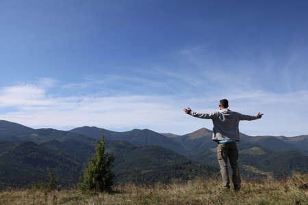 Man enjoying picturesque view of mountain landscape on sunny dayの写真素材