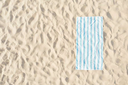 Striped beach towel on sand, aerial view. Space for textの写真素材