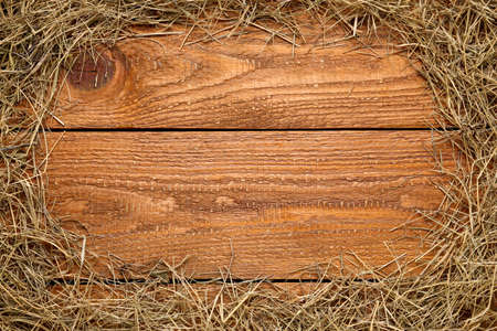 Frame made of dried hay on wooden background, top view. Space for textの写真素材